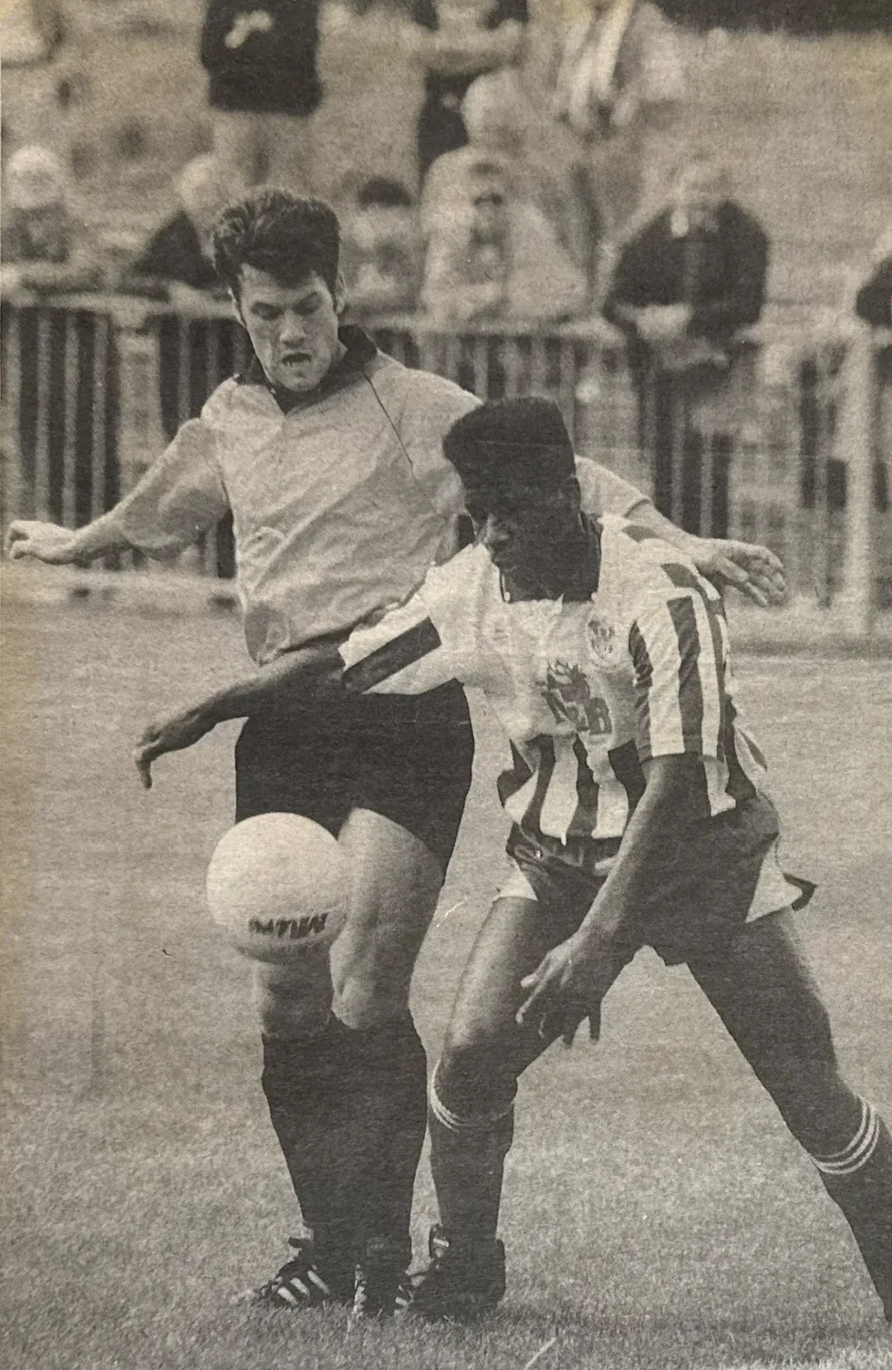 Mark Rosegreen in action, holding off a defender in a blue and white strip